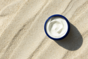 white cream in cosmetics bottle on the sand